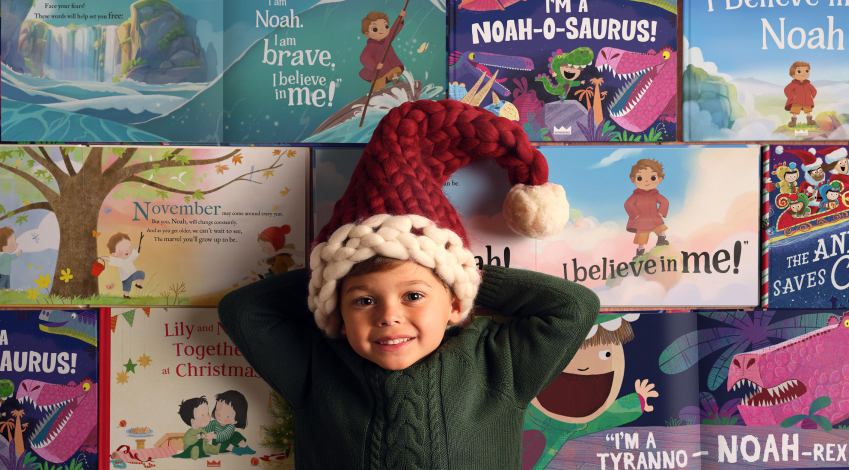 boy in santa hat smiling among wonderbly books